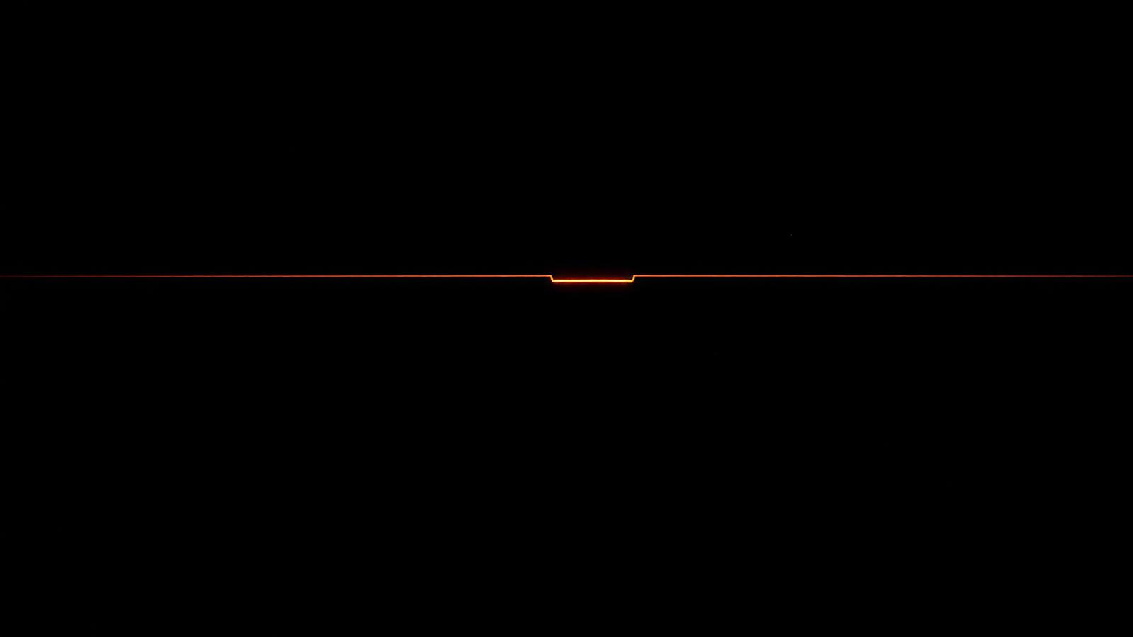 A single ember line running between two dark panels of stacked records