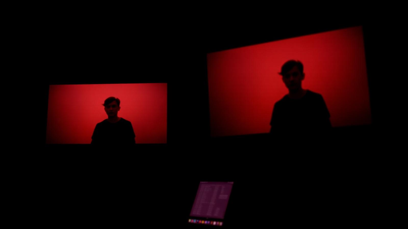 Two director monitors side by side showing the same paused interview frame