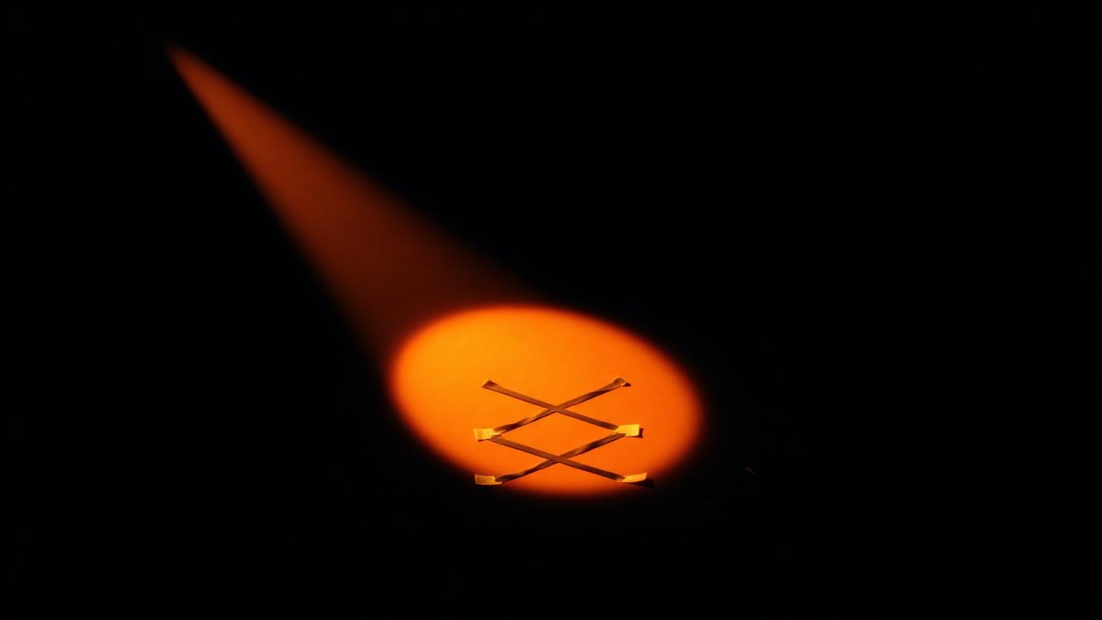 A warm ember stage light falling on an empty audition mark